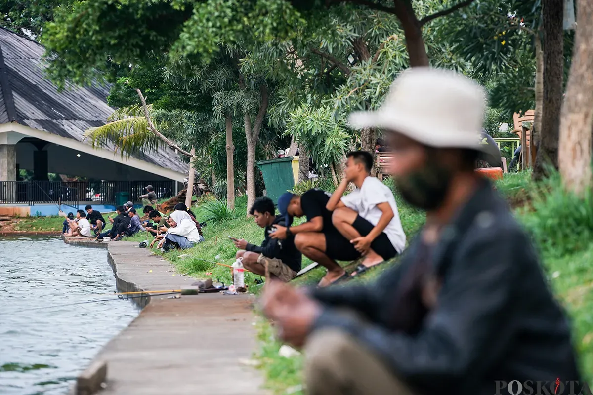 Warga mengisi waktu dengan berbagai macam aktivitas mulai dari olah raga ringan seperti lari hingga memancing ikan saat menunggu berbuka puasa di area Danau Sunter, Jakarta Utara, Kamis, 6 Maret 2025. (Sumber: Poskota/Bilal Nugraha Ginanjar)