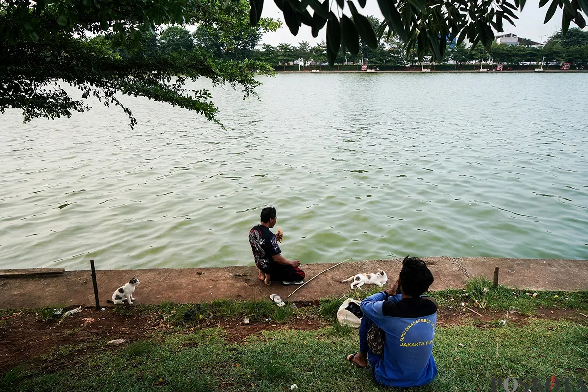 Warga mengisi waktu dengan berbagai macam aktivitas mulai dari olah raga ringan seperti lari hingga memancing ikan saat menunggu berbuka puasa di area Danau Sunter, Jakarta Utara, Kamis, 6 Maret 2025. (Sumber: Poskota/Bilal Nugraha Ginanjar)