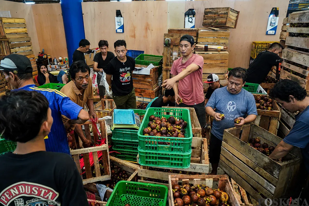 Sejumlah pedagang buah menyortir aneka buah-buahan segar yang akan dijualnya di Pasar Induk Kramat Jati, Jakarta Timur, Senin,10 Maret 2025. (Sumber: Poskota/Bilal Nugraha Ginanjar)