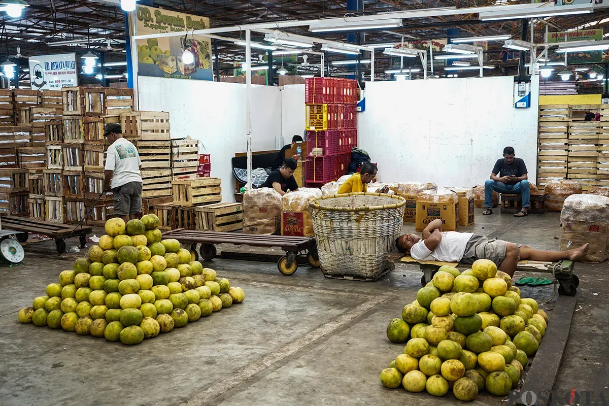 Sejumlah pedagang buah menyortir aneka buah-buahan segar yang akan dijualnya di Pasar Induk Kramat Jati, Jakarta Timur, Senin,10 Maret 2025. (Sumber: Poskota/Bilal Nugraha Ginanjar)