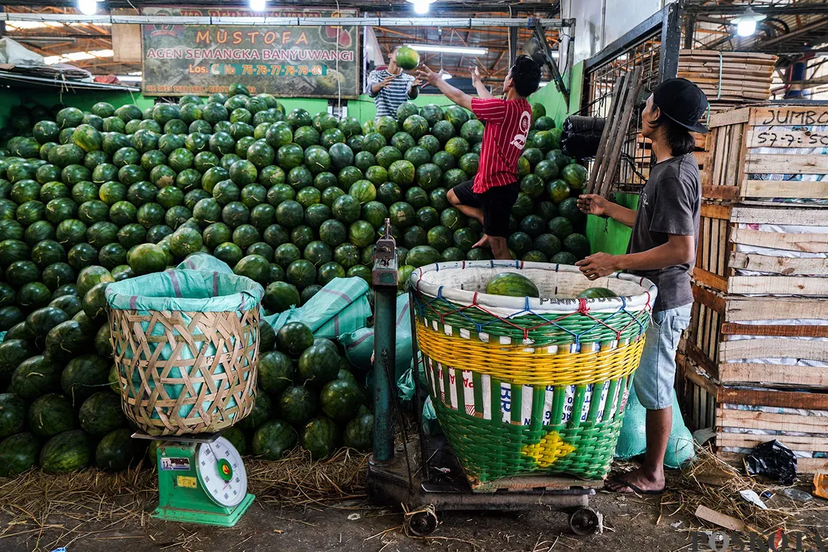 Sejumlah pedagang buah menyortir aneka buah-buahan segar yang akan dijualnya di Pasar Induk Kramat Jati, Jakarta Timur, Senin,10 Maret 2025. (Sumber: Poskota/Bilal Nugraha Ginanjar)