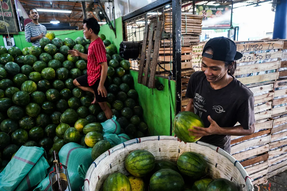 Sejumlah pedagang buah menyortir aneka buah-buahan segar yang akan dijualnya di Pasar Induk Kramat Jati, Jakarta Timur, Senin,10 Maret 2025. (Sumber: Poskota/Bilal Nugraha Ginanjar)