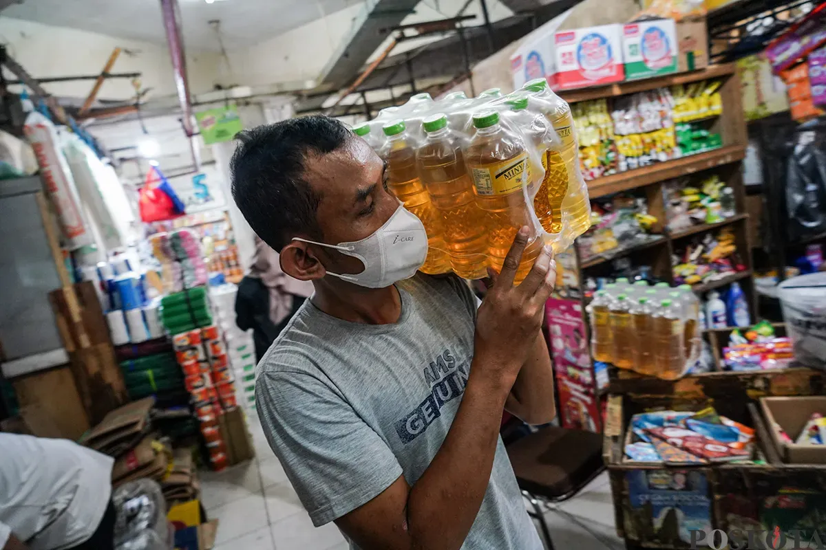 Seorang pedagang mengukur volume minyak merek minyakita di Pasar Tebet, Jakarta Selatan, Selasa, 11 Maret 2025. (Sumber: Poskoata/ Bilal Nugraha Ginanjar)