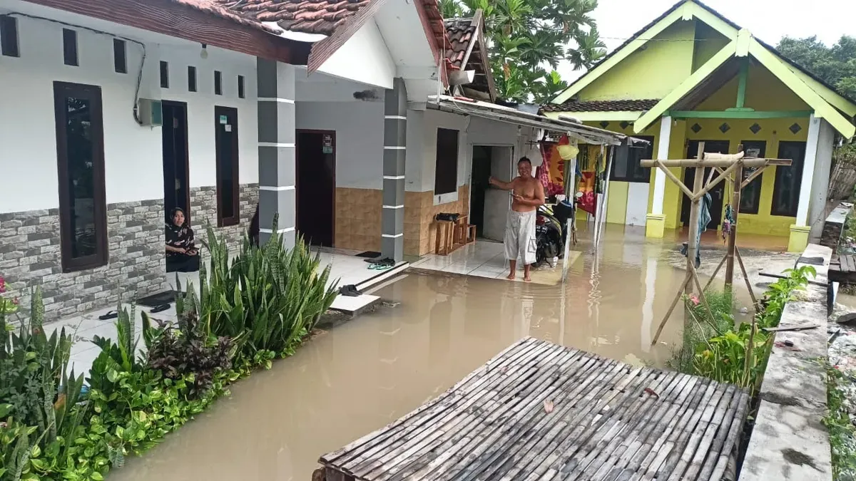 Seorang warga Probolinggo berada di teras rumah yang terendam banjir, BNPB melaporkan satu orang meninggal dunia akibat bencana banjir tersebut. (Sumber: Dok BNPB)