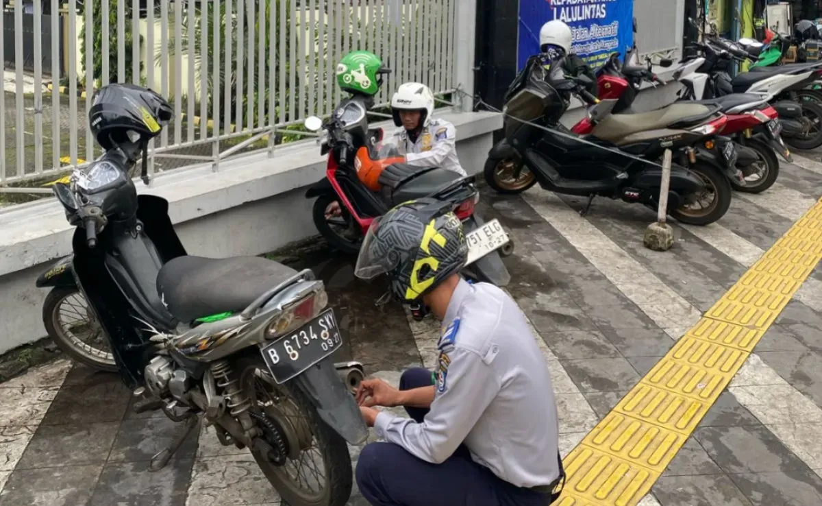 Petugas Dishub Kota Depok melakukan penertiban motor parkir liar diatas trotoar sepanjang Jalan Margonda. (Sumber: Dok. Dishub Kota Depok)