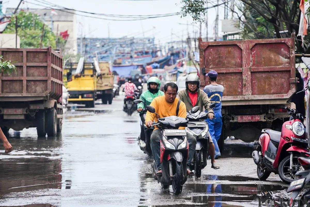 Pengendara motor di kawasan Muara Angke dan Muara Baru, Kamis, 13 Maret 2025. Warga menyebut barang-barang mereka, termasuk motor, cepat rusak karena kena air rob. (Sumber: Poskota/Bilal Nugraha Ginanjar)