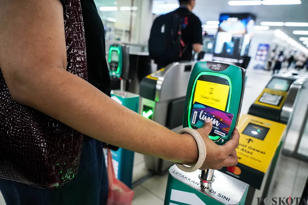 Calon penumpang menempelkan ponsel ke mesin pemindai untuk membayar kereta Moda Raya Terpadu (MRT) di Stasiun MRT Bundaran HI, Jakarta, Jumat 14 Maret 2025. (Sumber: Poskota/Bilal Nugraha Ginanjar)