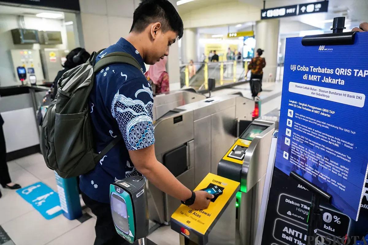 Calon penumpang menempelkan ponsel ke mesin pemindai untuk membayar kereta Moda Raya Terpadu (MRT) di Stasiun MRT Bundaran HI, Jakarta, Jumat 14 Maret 2025. (Sumber: Poskota/Bilal Nugraha Ginanjar)