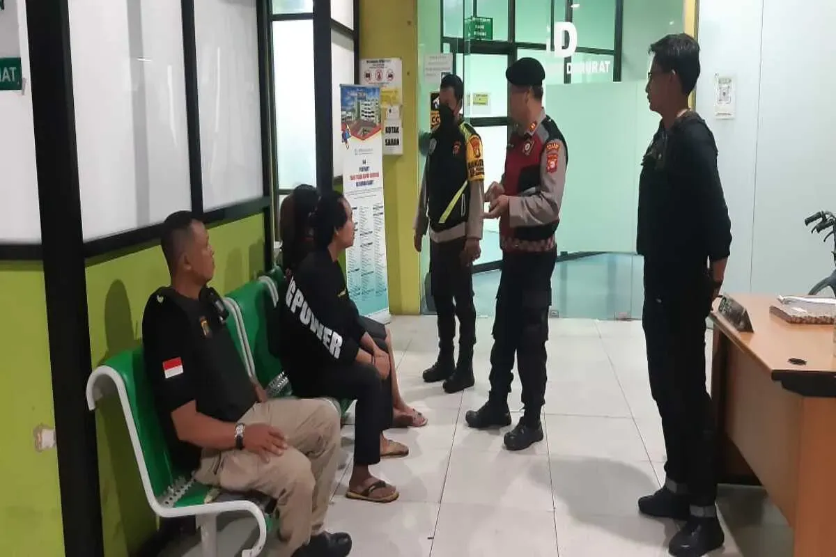 Petugas Polsek Bojongsari dibantu Mitra Pokdarkamtibmas mengamankan pelaku yang mengalami luka pada tangan di RSUD Depok usai mengamuk merusak toko vape. (Sumber: Dok. Polsek Bojongsari)