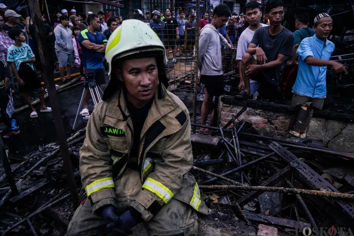 Petugas pemadam kebakaran beristirahat setelah melakukan pemadaman di Pasar Poncol, Senen, Jakarta Pusat, Selasa, 18 Maret 2025. (Sumber: Poskota/Bilal Nugraha Ginanjar)