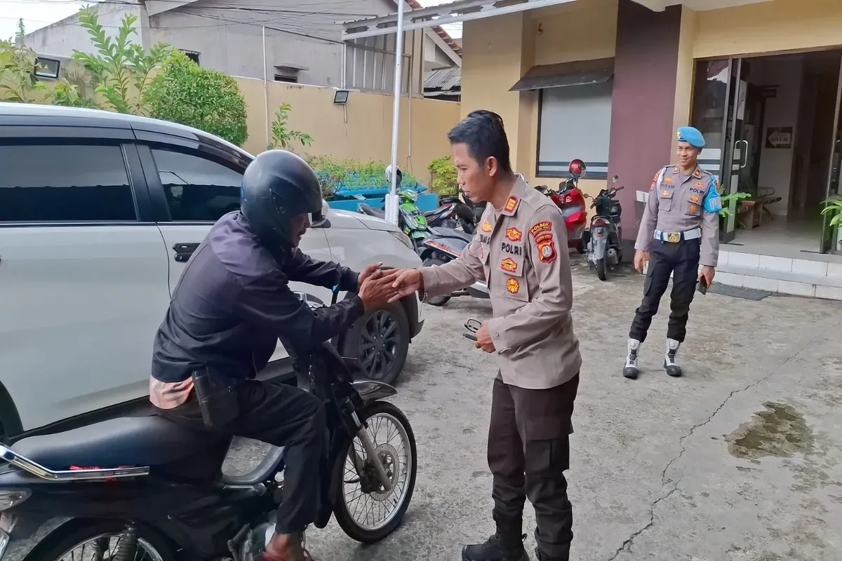 Kapolsek Bojonggede AKP Abdullah Syafiih didampingi Kanit Provos Polsek Bojonggede Iptu Tulus menerima pemudik asal Madura yang menitipkan motor di Mapolsek Bojonggede. (Sumber: Poskota/Angga Pahlevi)