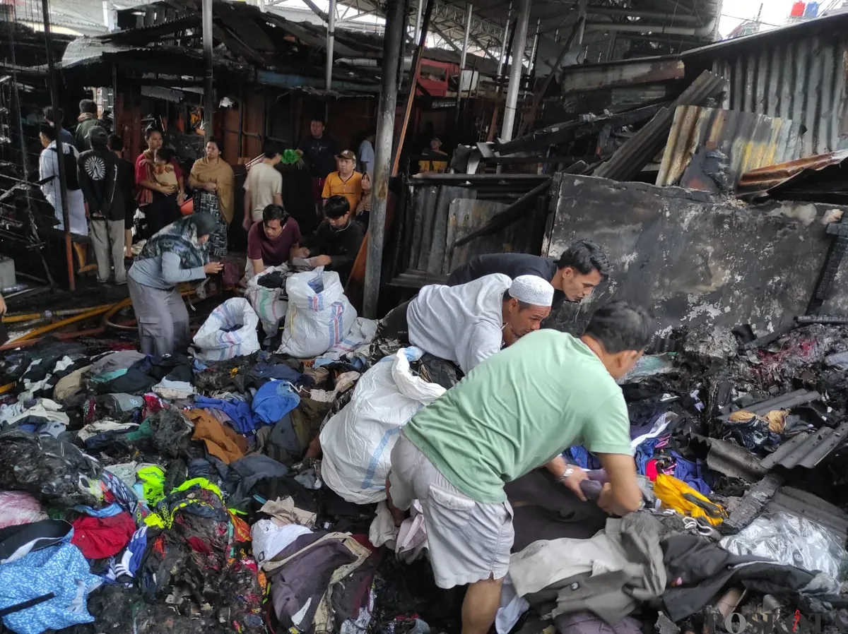 Sejumlah pedagang mengais sisa barang setelah kebakaran melanda puluhan kios pakaian di Pasar Poncol, Senen, Jakarta Pusat, Selasa, 18 Maret 2025. (Sumber: Poskota/Ade Mamad)