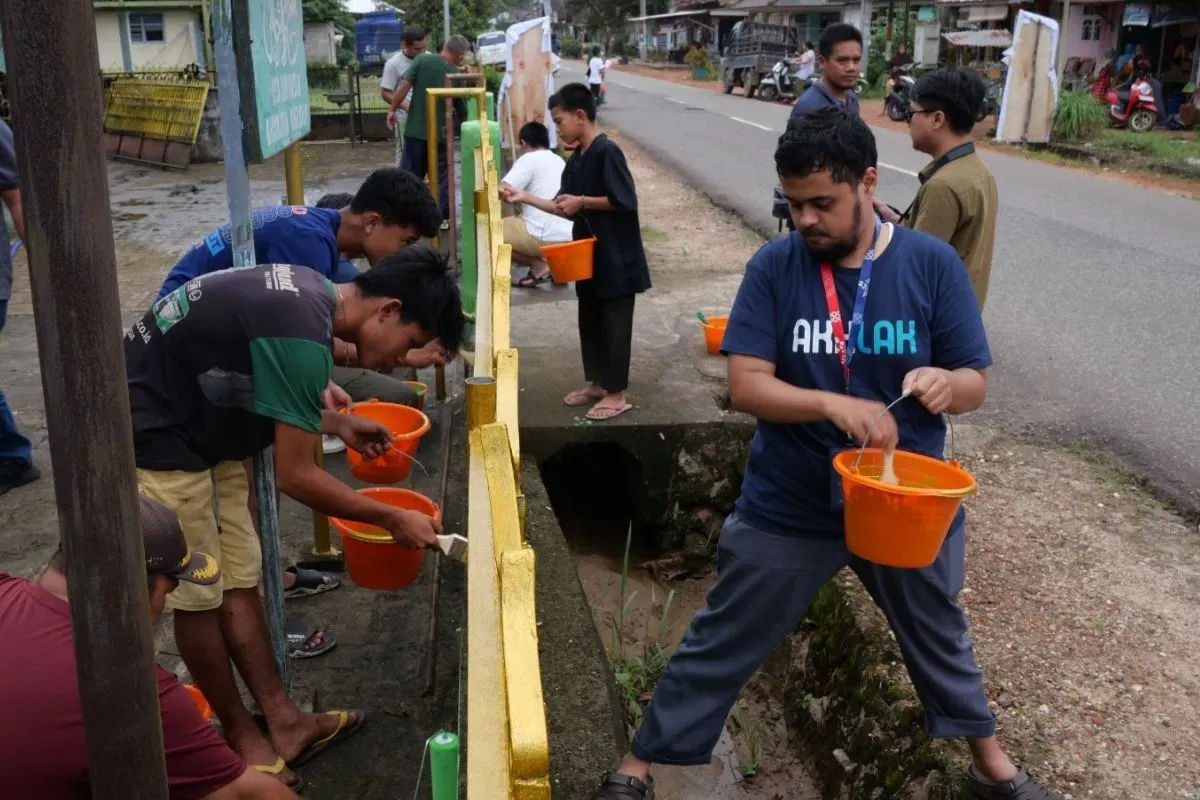 Beberapa Relawan saat melakukan kegiatan gotong royong mengecat pagar masjid bersama masyarakat setempat di Desa Banyuasin, Kecamatan Riau Silip, Kabupaten Bangka, Kepulauan Bangka Belitung, Sabtu, 15 Maret 2025. (Sumber: Dok. Telkom)