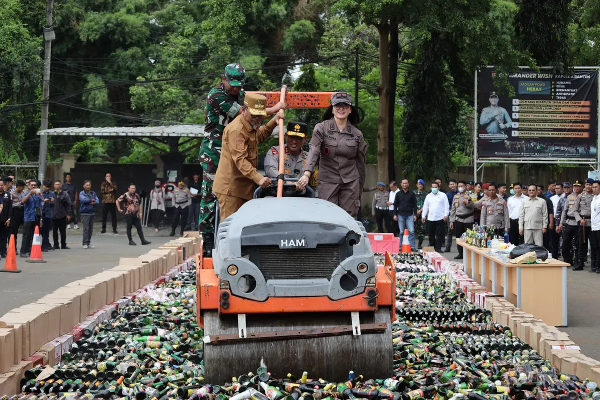 Pemusnahan minuman keras hasil operasi pekat maung selama satu bulan lebih di halaman Mapolda Banten, Kamis, 20 Maret 2025. (Sumber: Dok. Bidhumas Polda Banten)