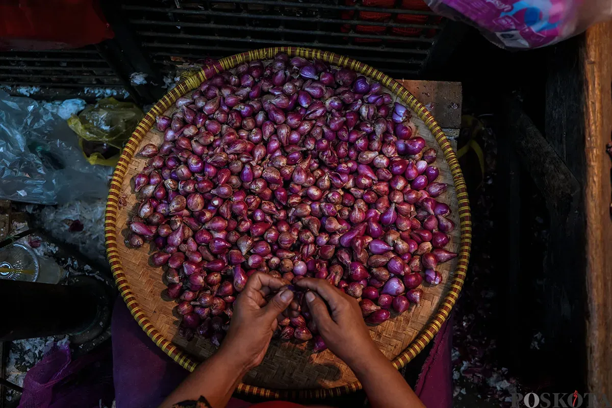 Pedagang memilah bawang merah dan bawang putih impor yang akan dijual ke pembeli di Pasar Induk Kramat Jati, Jakarta Timur, Kamis, 1 Mei 2025. (Sumber: Poskota/Bilal Nugraha Ginanjar)