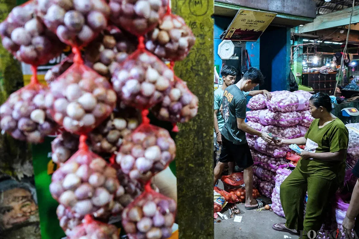 Pedagang memilah bawang merah dan bawang putih impor yang akan dijual ke pembeli di Pasar Induk Kramat Jati, Jakarta Timur, Kamis, 1 Mei 2025. (Sumber: Poskota/Bilal Nugraha Ginanjar)