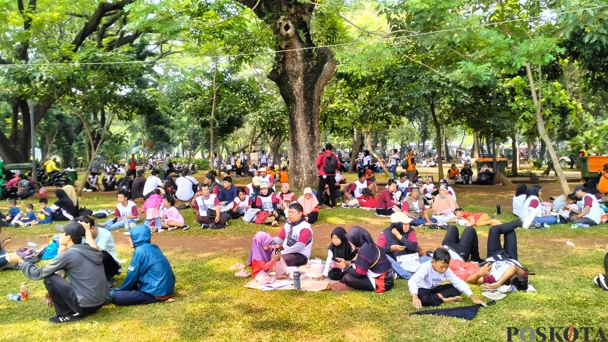 Massa aksi sedang berteduh di bawah pohon di Kawasan Monas, Jakarta Pusat, Kamis 1 Mei 2025. (Sumber: Poskota/M. Tegar Jihad)