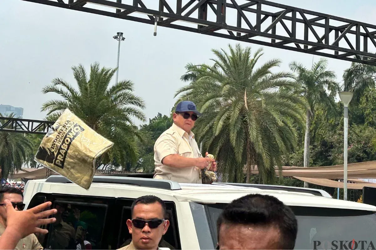 Presiden Prabowo Subianto saat melempar-lemparkan baju kepada massa buruh di Kawasan Monas, Jakarta Pusat, Kamis, 1 Mei 2025. (Sumber: Poskota/M. Tegar Jihad)