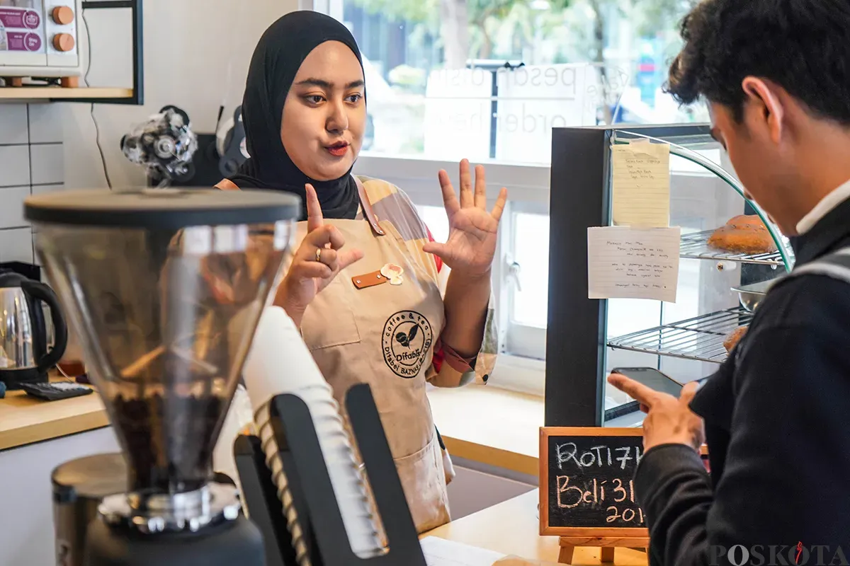 Pekerja sekaligus penyandang disabilitas menyiapkan kopi dan roti yang dipesan pelanggan di Kopi Difabis Terowongan Kendal, Dukuh Atas, Jakarta, Jumat, 2 Mei 2025. (Sumber: Poskota/Bilal Nugraha Ginanjar)