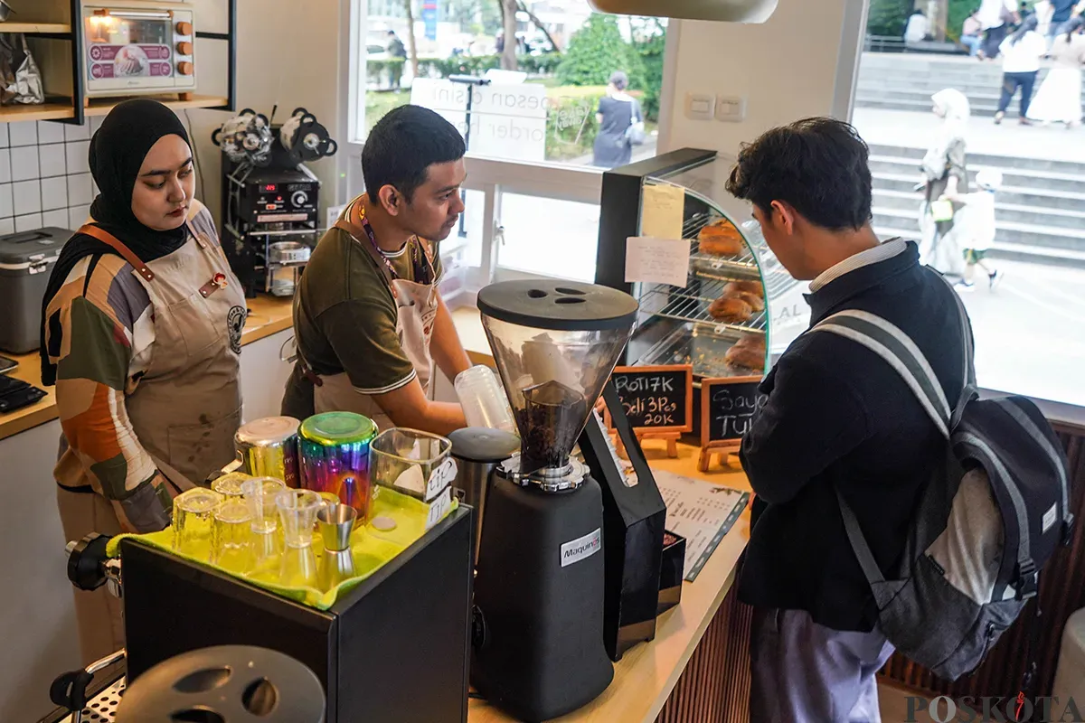Pekerja sekaligus penyandang disabilitas menyiapkan kopi dan roti yang dipesan pelanggan di Kopi Difabis Terowongan Kendal, Dukuh Atas, Jakarta, Jumat, 2 Mei 2025. (Sumber: Poskota/Bilal Nugraha Ginanjar)