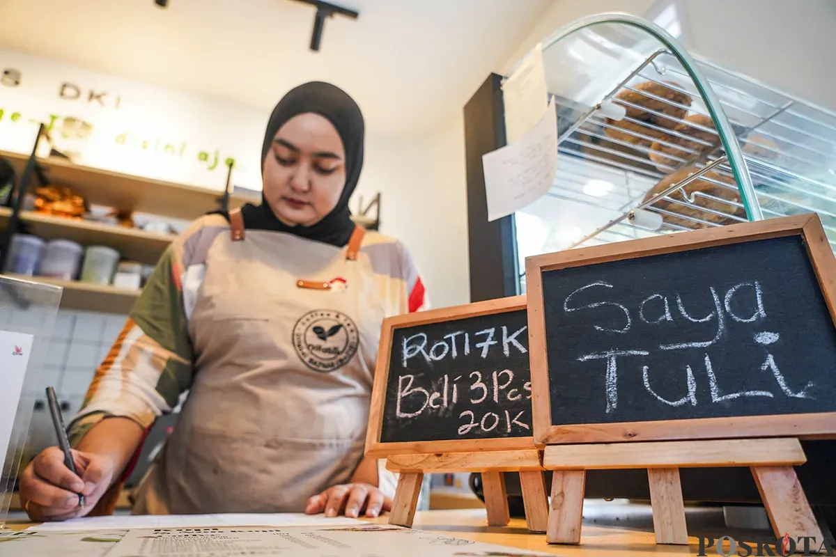 Pekerja sekaligus penyandang disabilitas menyiapkan kopi dan roti yang dipesan pelanggan di Kopi Difabis Terowongan Kendal, Dukuh Atas, Jakarta, Jumat, 2 Mei 2025. (Sumber: Poskota/Bilal Nugraha Ginanjar)