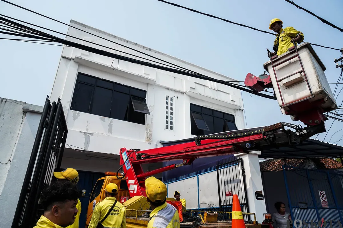 Petugas Dinas Bina Marga memotong kabel utilitas yang dianggap menganggu dan berpotensi membahayakan di kawasan Cideng, Jakarta, Jumat, 1 Mei 2025. (Sumber: Poskota/Bilal Nugraha Ginanjar)