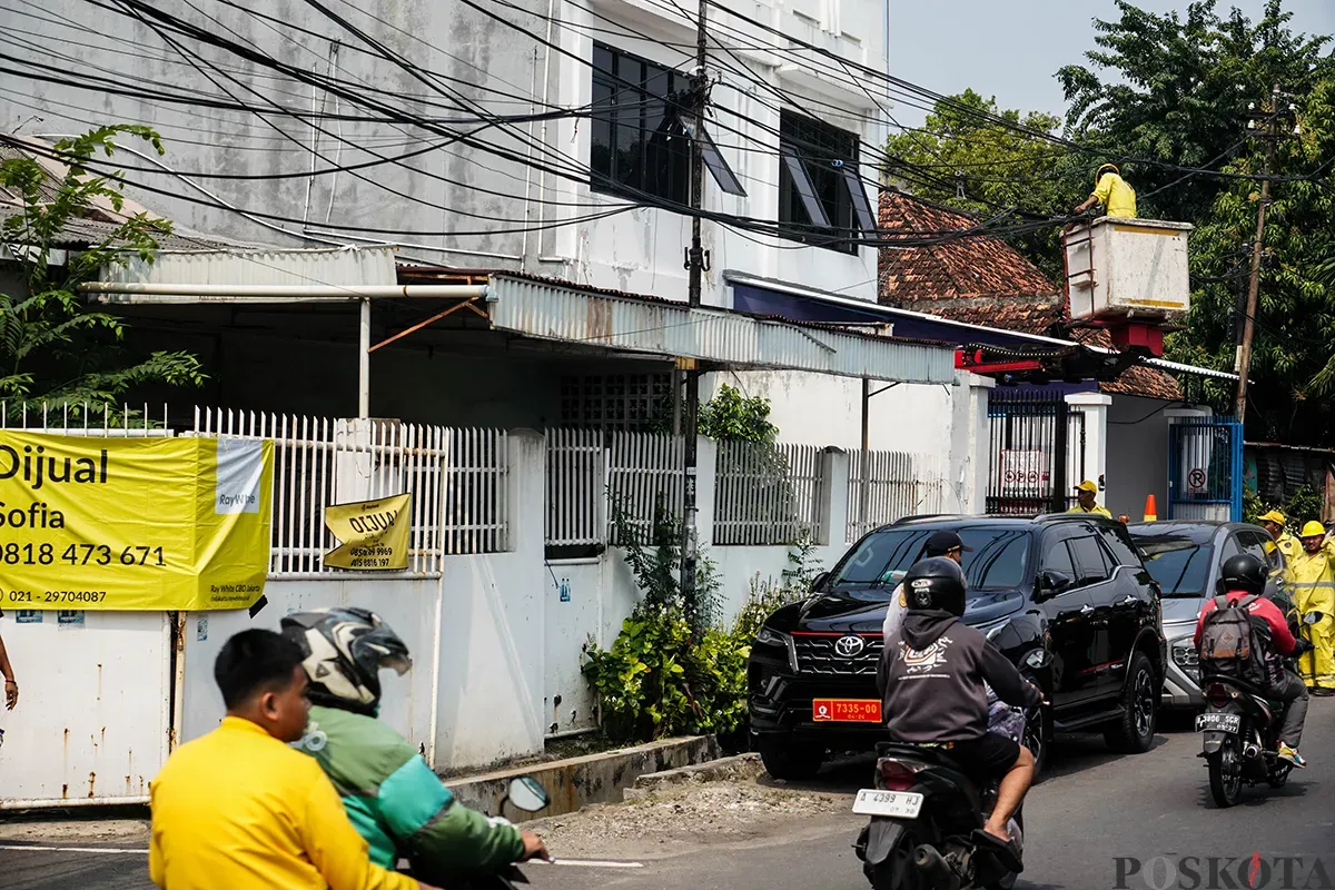 Petugas Dinas Bina Marga memotong kabel utilitas yang dianggap menganggu dan berpotensi membahayakan di kawasan Cideng, Jakarta, Jumat, 1 Mei 2025. (Sumber: Poskota/Bilal Nugraha Ginanjar)