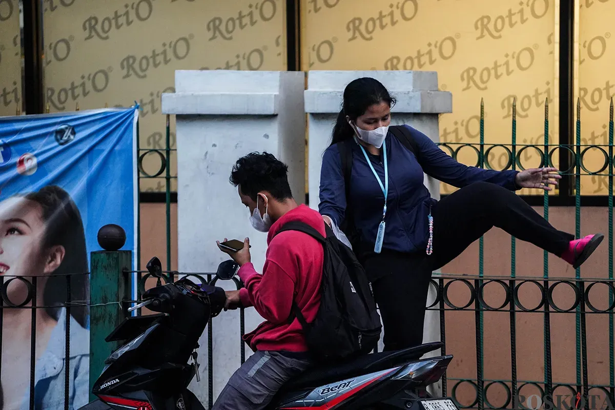 Sejumlah calon penumpang kereta api rela melompati pagar pembatas di depan Stasiun Cikini, Jakarta, Minggu, 4 Mei 2025. (Sumber: Poskota/Bilal Nugraha Ginanjar)