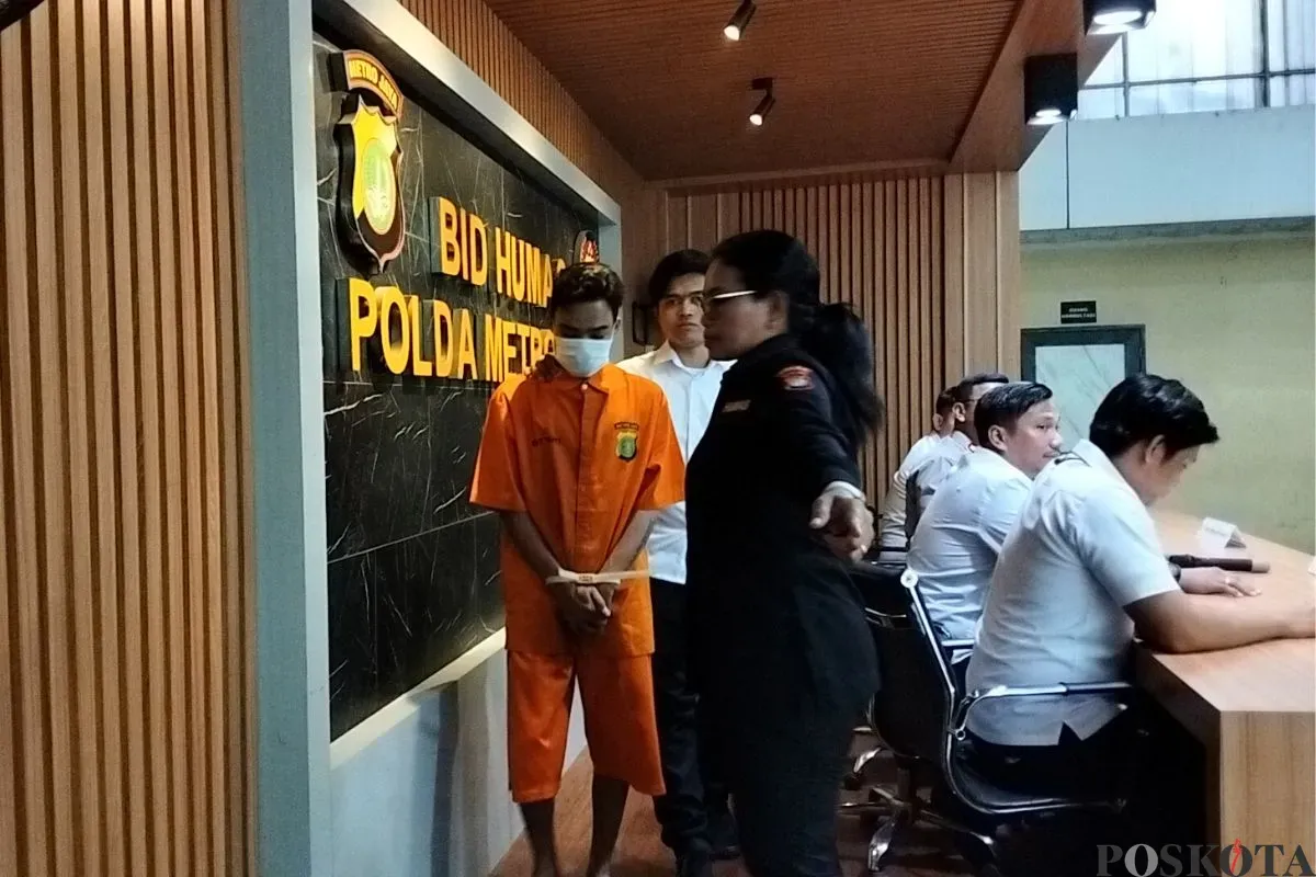 Tersangka pemerasan disertai ancaman penyebaran konten seksual alias Video Call Sex (VCS) saat digiring petugas di Mapolda Metro Jaya, Jakarta Selatan, Selasa, 6 Mei 2025. (Sumber: Poskota/Ali Mansur)
