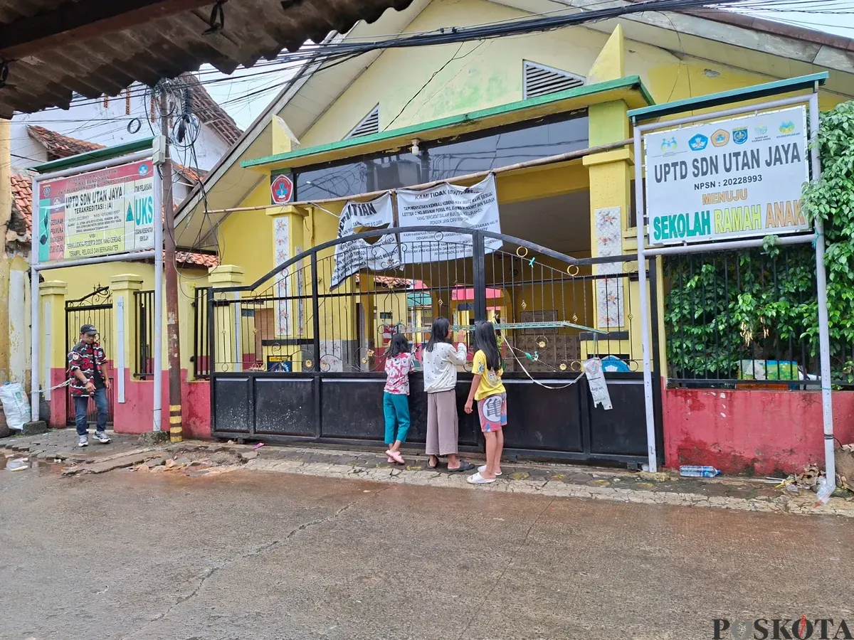 Tiga orang anak berdiri di depan gerbang sekolah mereka, SDN Utan Jaya, yang disegel ahli waris. (Sumber: Poskota/Angga Pahlevi)