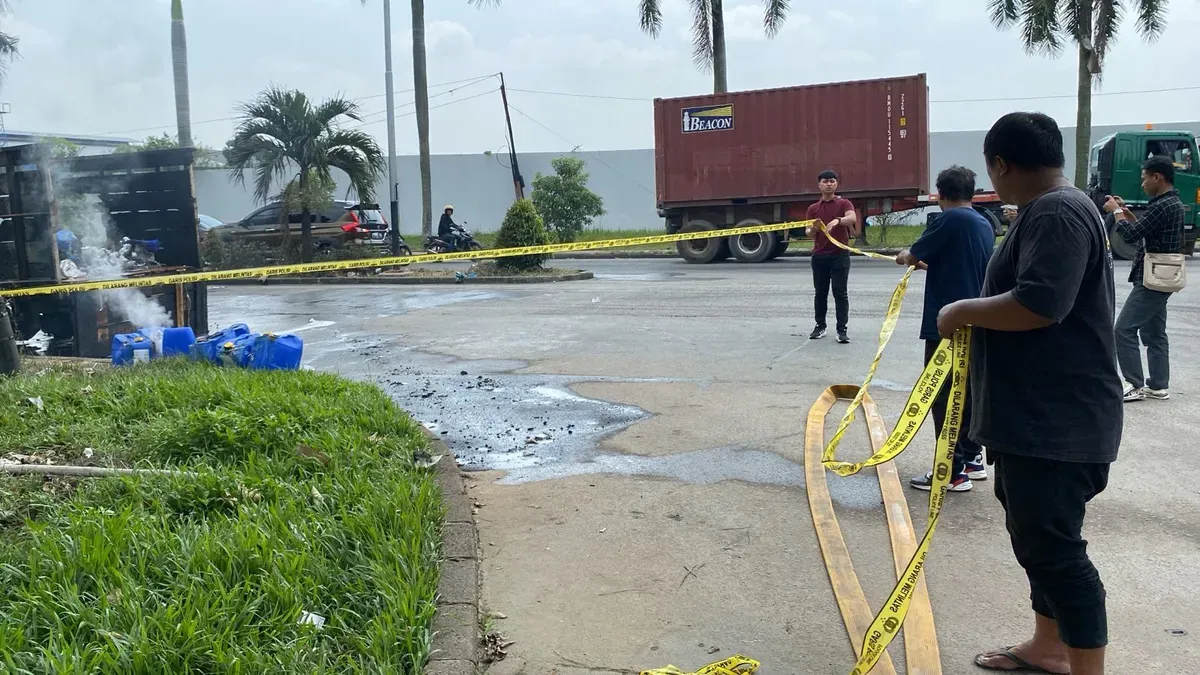 Personel Unit Reskrim Polsek Cikande memasang garis polisi di TKP truk pengangkut bahan kimia yang terbakar. (Sumber: Polsek Cikande)