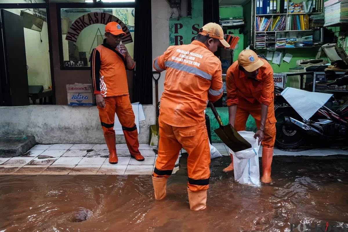 Sejumlah Petugas Suku Dinas Sumber Daya Air dan PPSU membersihkan sisa-sisa puing tembok pembatas yang ambruk di Jalan Kalibata Timur Raya, Jakarta Selatan, Rabu, 7 Mei 2025. (Sumber: Poskota/Bilal Nugraha Ginanjar)