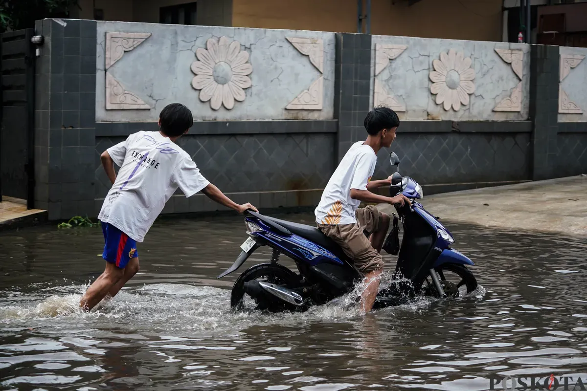 Pengendara motor melintasi genangan banjir di Jalan Pondok Karya, Jakarta Selatan, Rabu, 7 Mei 2025. (Sumber: Poskota/Bilal Nugraha Ginanjar)