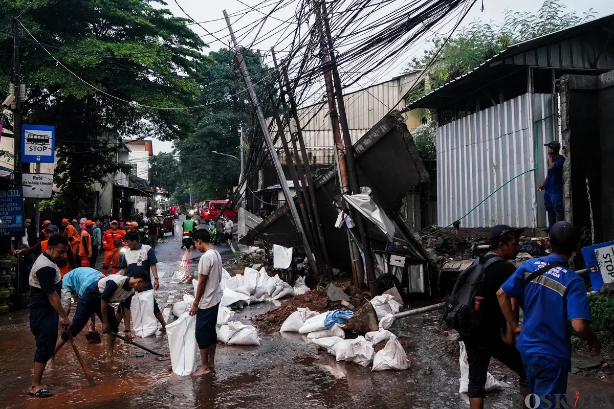 Sejumlah Petugas Suku Dinas Sumber Daya Air dan PPSU membersihkan sisa-sisa puing tembok pembatas yang ambruk di Jalan Kalibata Timur Raya, Jakarta Selatan, Rabu, 7 Mei 2025. (Sumber: Poskota/Bilal Nugraha Ginanjar)