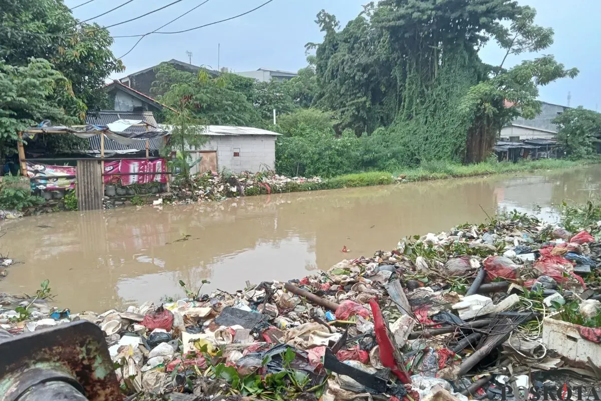 Air kali di Jalan, Teluk Pucung, Bekasi Utara, Kabupaten Bekasi meluap seusai diterjang hujan deras sejak pagi hari, Sabtu, 10 Mei 2025. (Sumber: Poskota/Nurpini Aulia Rapika)