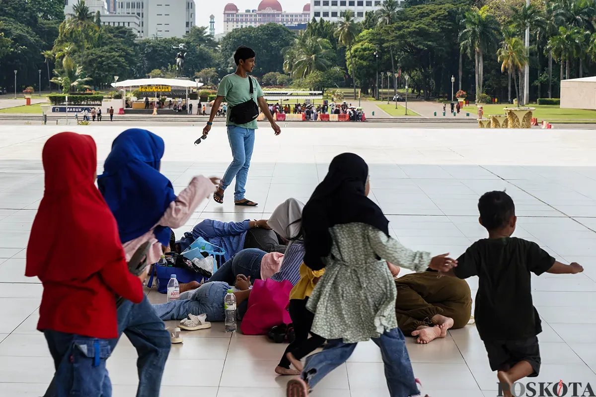 Sejumlah pengunjung menikmati sejumlah fasilitas wisata yang tersedia di kawasan Tugu Monumen Nasional (Monas), Jakarta, Selasa, 13 Mei 2025. (Sumber: Poskota/Bilal Nugraha Ginanjar)
