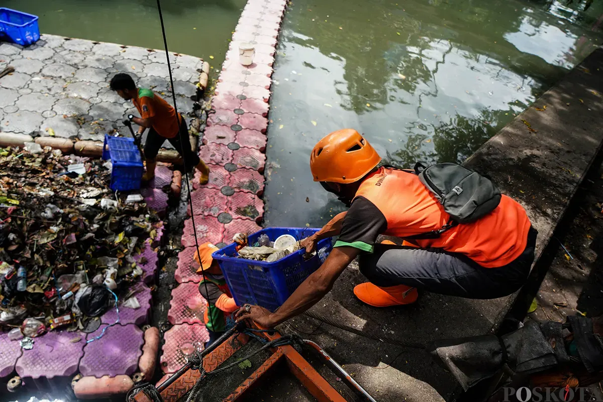 Petugas Unit Penanganan Sampah Badan Air (UPS Badan Air) Kecamatan Tanah Abang membersihkan tumpukan sampah yang mengendap di aliran Kali Cideng, Tanah Abang, Jakarta, Selasa, 13 Mei 2025. (Sumber: Poskota/Bilal Nugraha Ginanjar)