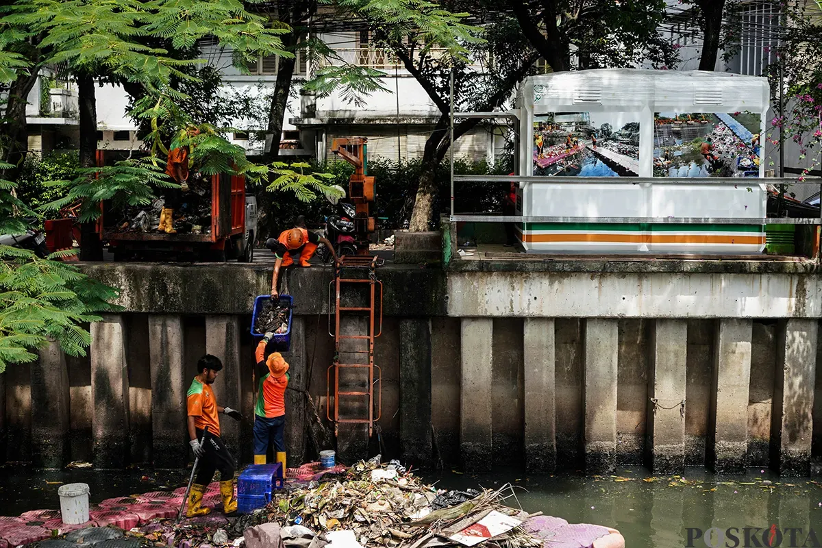 Petugas Unit Penanganan Sampah Badan Air (UPS Badan Air) Kecamatan Tanah Abang membersihkan tumpukan sampah yang mengendap di aliran Kali Cideng, Tanah Abang, Jakarta, Selasa, 13 Mei 2025. (Sumber: Poskota/Bilal Nugraha Ginanjar)