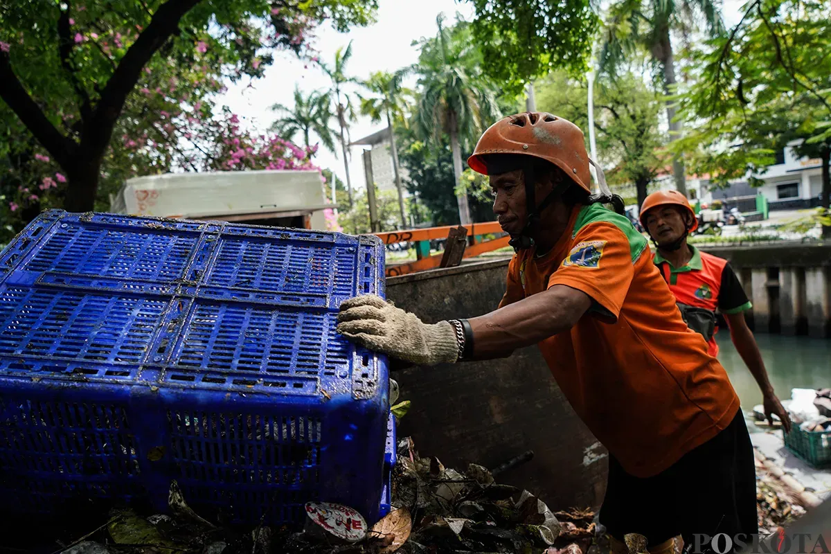 Petugas Unit Penanganan Sampah Badan Air (UPS Badan Air) Kecamatan Tanah Abang membersihkan tumpukan sampah yang mengendap di aliran Kali Cideng, Tanah Abang, Jakarta, Selasa, 13 Mei 2025. (Sumber: Poskota/Bilal Nugraha Ginanjar)