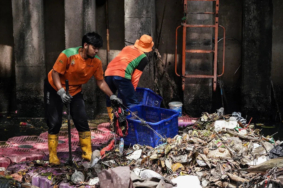 Petugas Unit Penanganan Sampah Badan Air (UPS Badan Air) Kecamatan Tanah Abang membersihkan tumpukan sampah yang mengendap di aliran Kali Cideng, Tanah Abang, Jakarta, Selasa, 13 Mei 2025. (Sumber: Poskota/Bilal Nugraha Ginanjar)