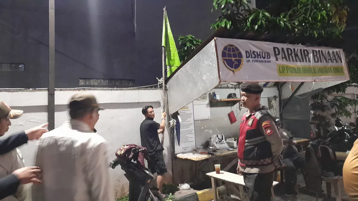 Polsek Cipayung bersama Satpol PP menertibkan bendera ormas yang terpasang di rumah makan. (Sumber: Dok. Humas Polsek Cipayung)