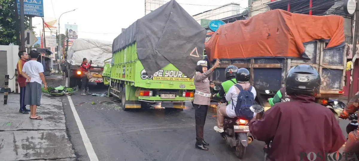 Polisi mengatur arus lalu lintas di sekitar TKP kecelakaan yang melibatkan dua unit truk kawasan Jalan Raya Jakarta-Bogor, Kecamatan Bogor Utara, Kota Bogor. (Sumber: Poskota/Sekar Putri Andini)