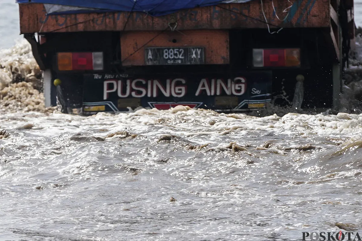 Ilustrasi Banjir - Sejumlah kendaraan berupaya melintasi jalan yang tergenang banjir rob di kawasan Pelabuhan Sunda Kelapa, Jakarta Utara, Rabu, 14 Mei 2025. (Sumber: Poskota/Bilal Nugraha Ginanjar)