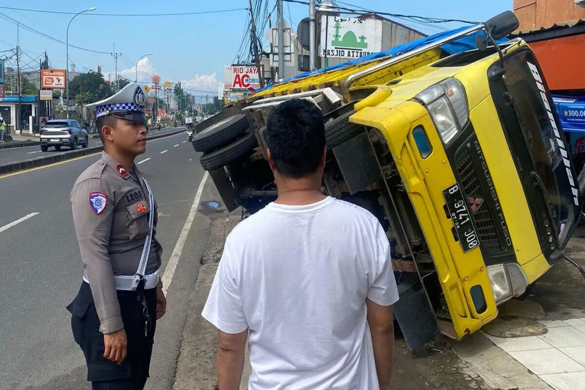 Satu unit truk bermuatan bahan bangunan anjlok ke dalam gorong-gorong depan salah satu toko di Bojongsari, Kota Depok, Rabu, 14 Mei 2025. (Sumber: Polsek Bojongsari)