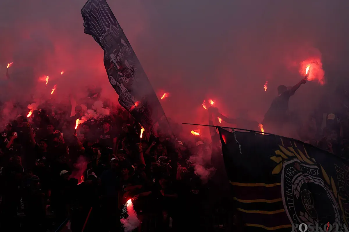 Suporter Persita Tangerang saat menyalakan flare di tribun penonton. (Sumber: Poskota/Bilal Nugraha Ginanjar)