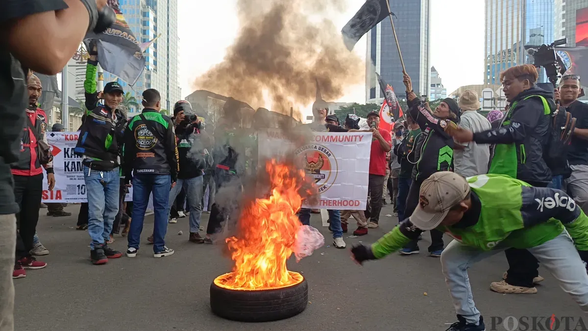 Aksi driver ojek online (Ojol) membakar ban bekas di kawasan Patung Kuda atau Patung Kuda Arjuna Wijaya, Jakarta Pusat, Selasa, 20 Mei 2025. (Sumber: Poskota/Ali Mansur)