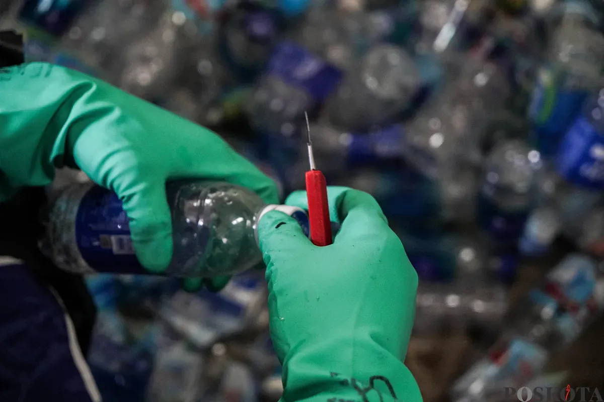 Petugas mengerjakan proses pengolahan limbah botol plastik menjadi cacahan di Waste Treatment Plant di komplek olahraga stadion Gelora Bung Karno (GBK), Jakarta, Kamis, 22 Mei 2025. (Sumber: Poskota/Bilal Nugraha Ginanjar)