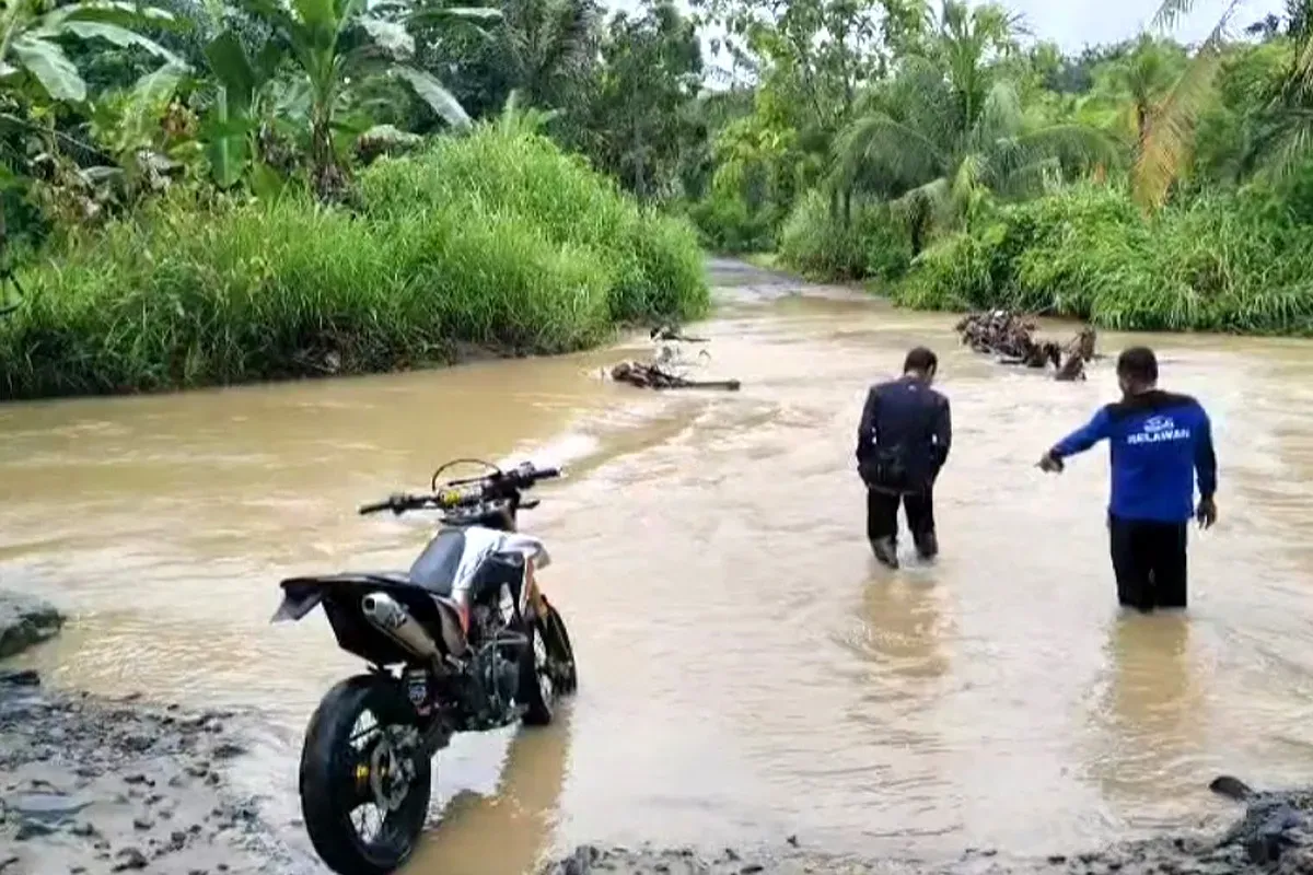 Sejumlah warga di Desa Cikeusik, Kecamatan Cikeusik, Pandeglang, saat hendak melintas jembatan yang terendam banjir. (Sumber: Dok. Warga)