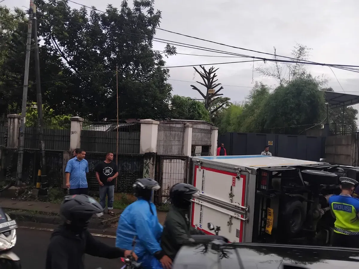 Petugas Unit Laka Lantas Polres Metro Depok mengevakuasi truk yang terguling di Jalan Raya Bojongsari - Ciputat, Senin, 26 Mei 2025, pagi. (Sumber: Polres Metro Depok)