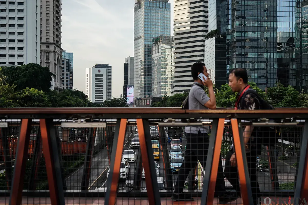 Pekerja melintasi pedestrian saat jam pulang kerja di kawasan Jalan Jenderal Sudirman, Jakarta, Selasa, 27 Mei 2025. (Sumber: Poskota/Bilal Nugraha Ginanjar)